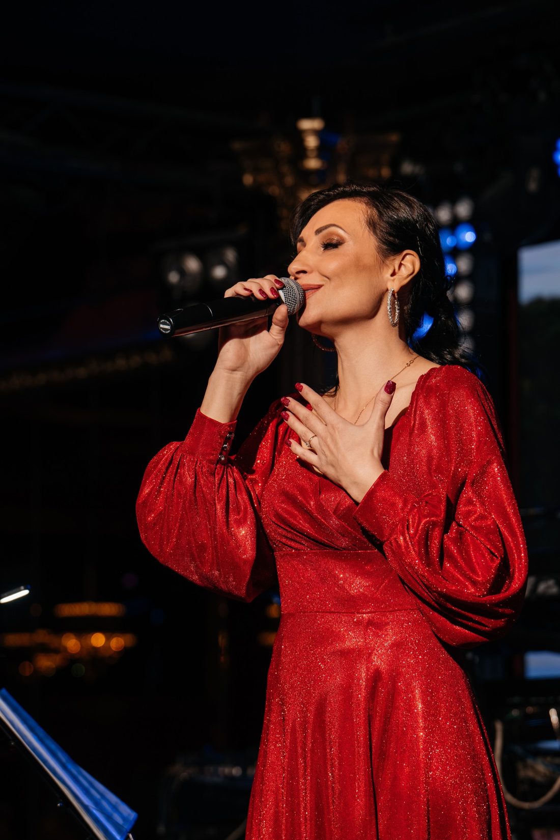 Марина Кузнецова поёт на сцене в красном платье